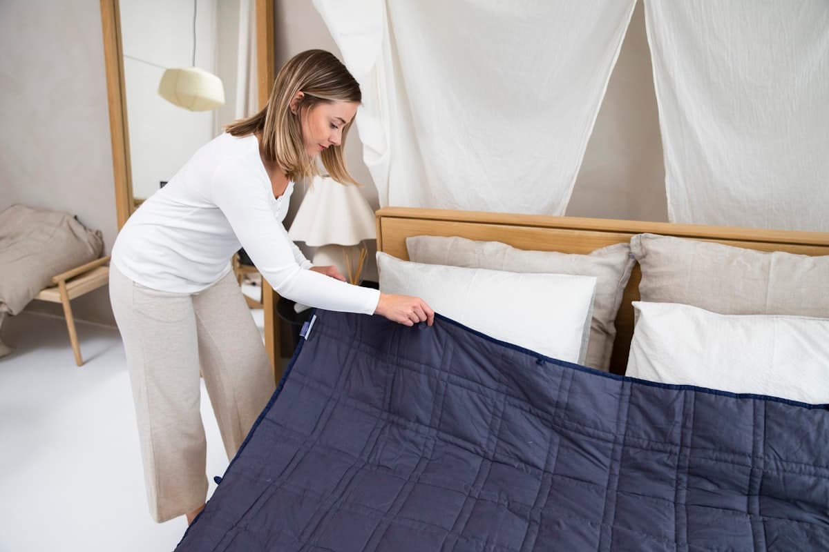 Tendiendo la cama y acomodando las almohadas antes de que llegue el huésped
