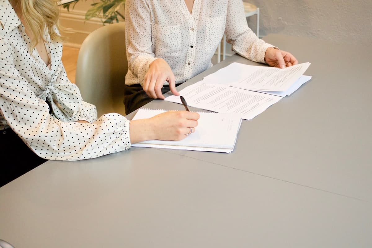 Revisando juntos un contrato impreso, señalando una cláusula